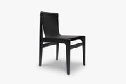Front-angle view of the Burano dining chair in Nero black leather with a black-stained solid ash frame on white.