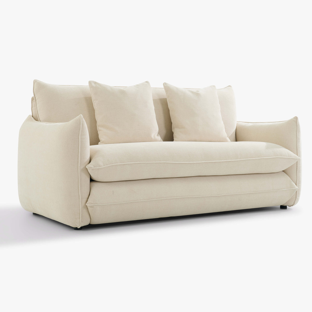 Angled front view of the Blossom sofa bed in Bisque with curved arms, back cushions and two decorative cushions.