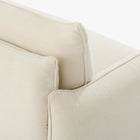 Close-up of the Blossom sofa bed in Bisque, showing the curved arm, cushion edges and stitched upholstery detail.