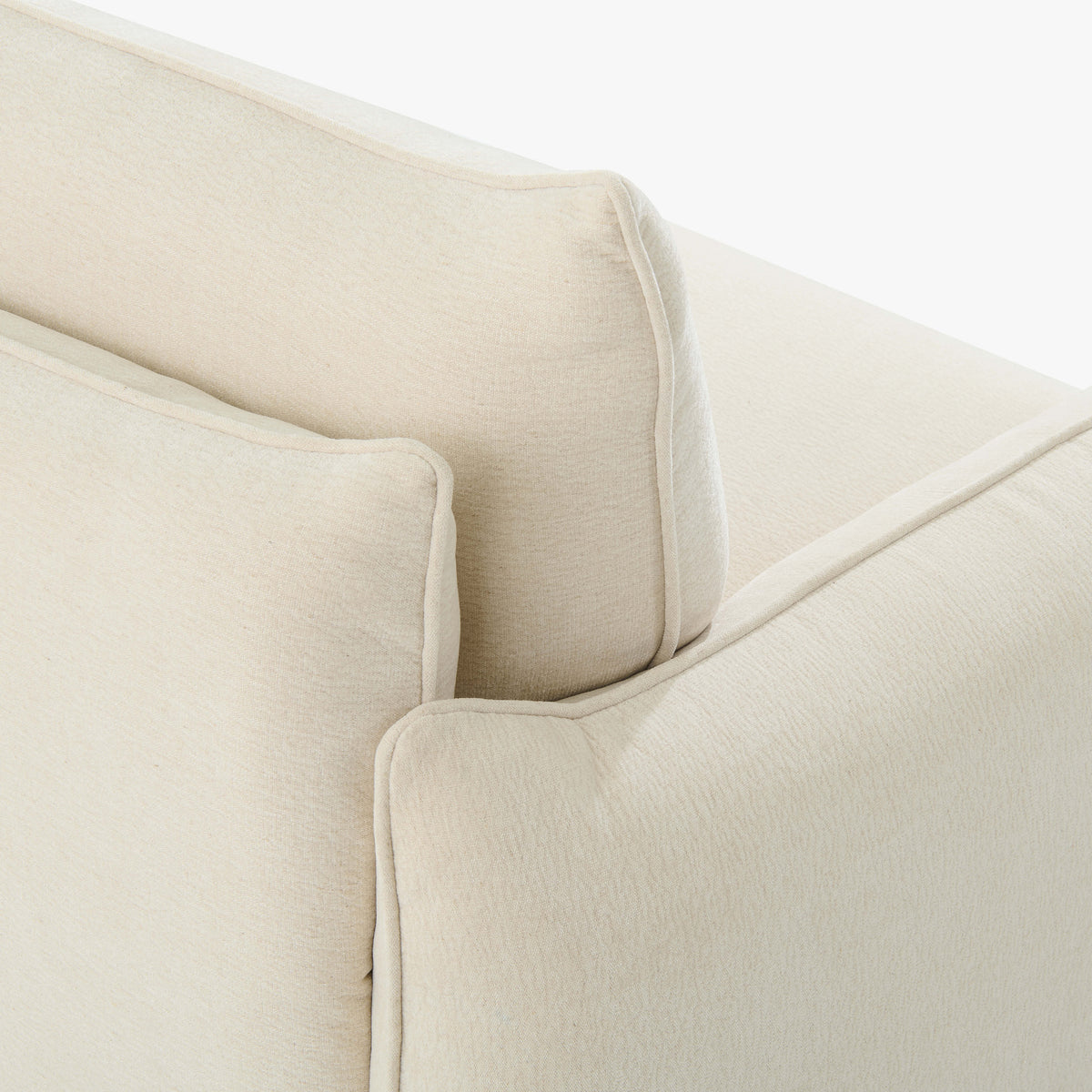 Close-up of the Blossom sofa bed in Bisque, showing the curved arm, cushion edges and stitched upholstery detail.