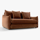 Angled front view of the Blossom sofa bed in Bronze with curved arms, back cushions and two decorative cushions.