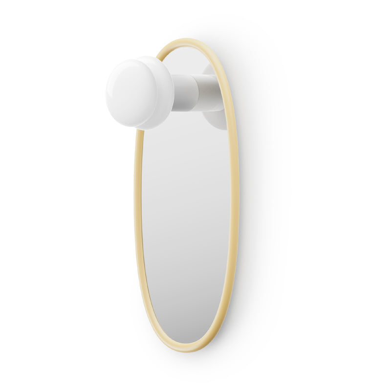 Oval shaped mirror with butter yellow frame and a portable lamp on a white background