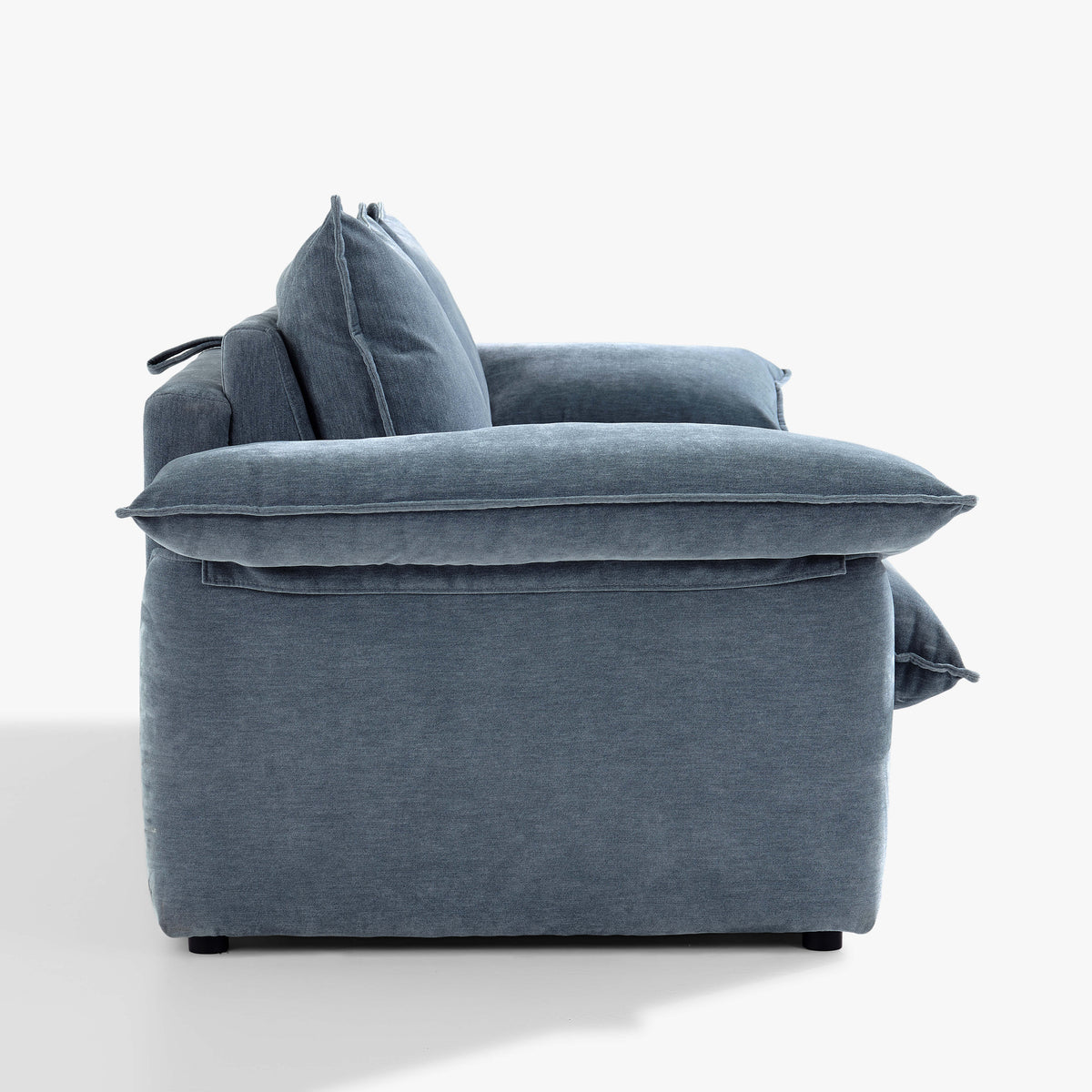 Side view of the Ease sofa bed in Celestine, showing the cushioned arm, upholstered base and back cushions.