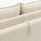 Close-up of the Ease sofa bed in Bisque, showing textured upholstery, back cushions and the fabric pull loop.