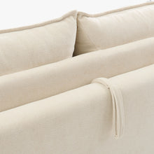 Close-up of the Ease sofa bed in Bisque, showing textured upholstery, back cushions and the fabric pull loop.