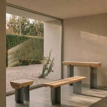 Forma Atelier side table, bench seat and console in Douglas fir and stainless steel beside a garden-facing window.