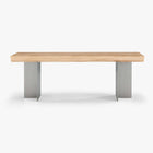 Front view of the Forma Atelier bench seat showing the long Douglas fir seat and two stainless steel supports.