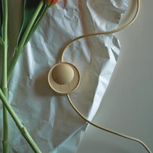 Beige electronic lamp controller with  the cord on crumpled white paper