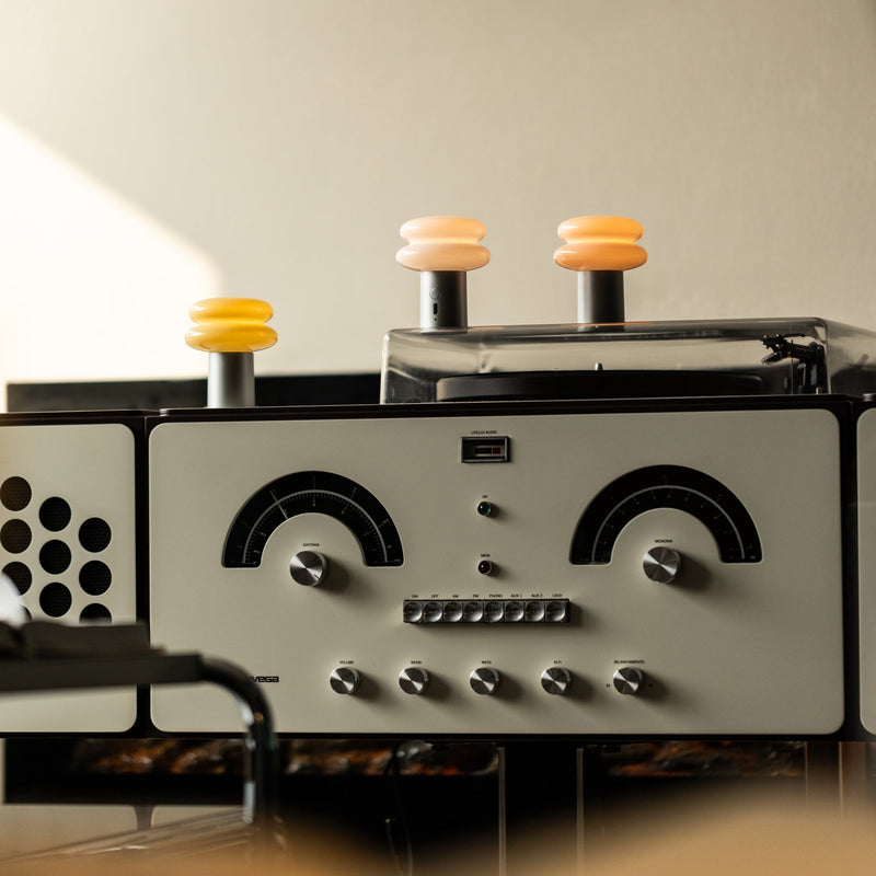 Vintage-style radio with three portable lamps on a neutral background