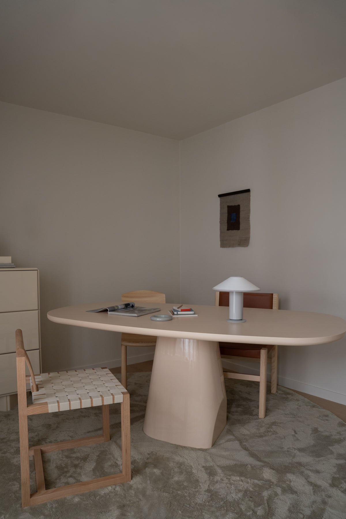 Trovato Penthouse showroom consultation area with an oval table, timber chairs and sculptural lamp