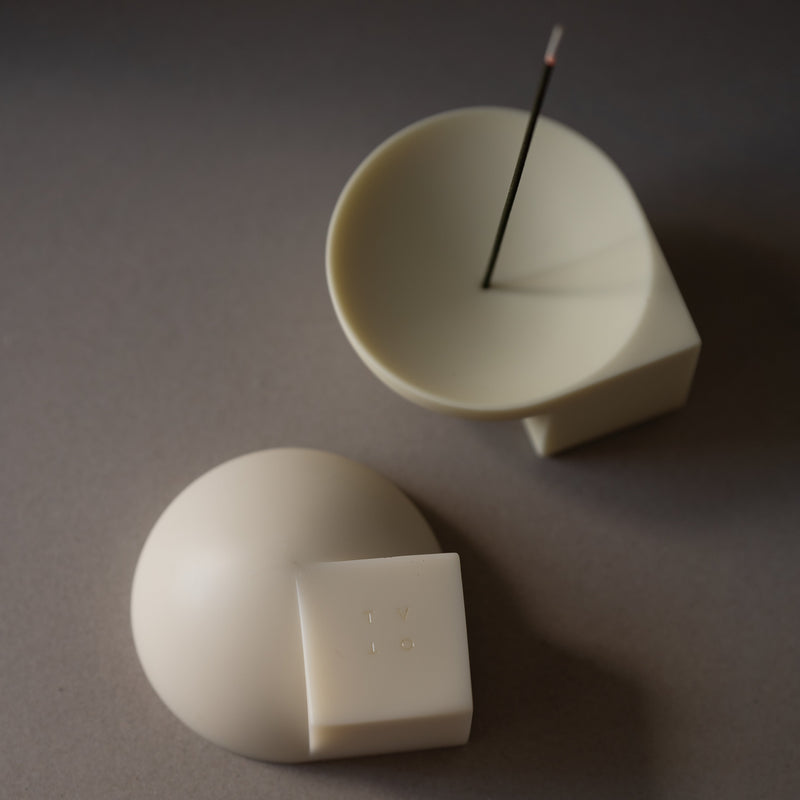 Two resin objects on a grey surface