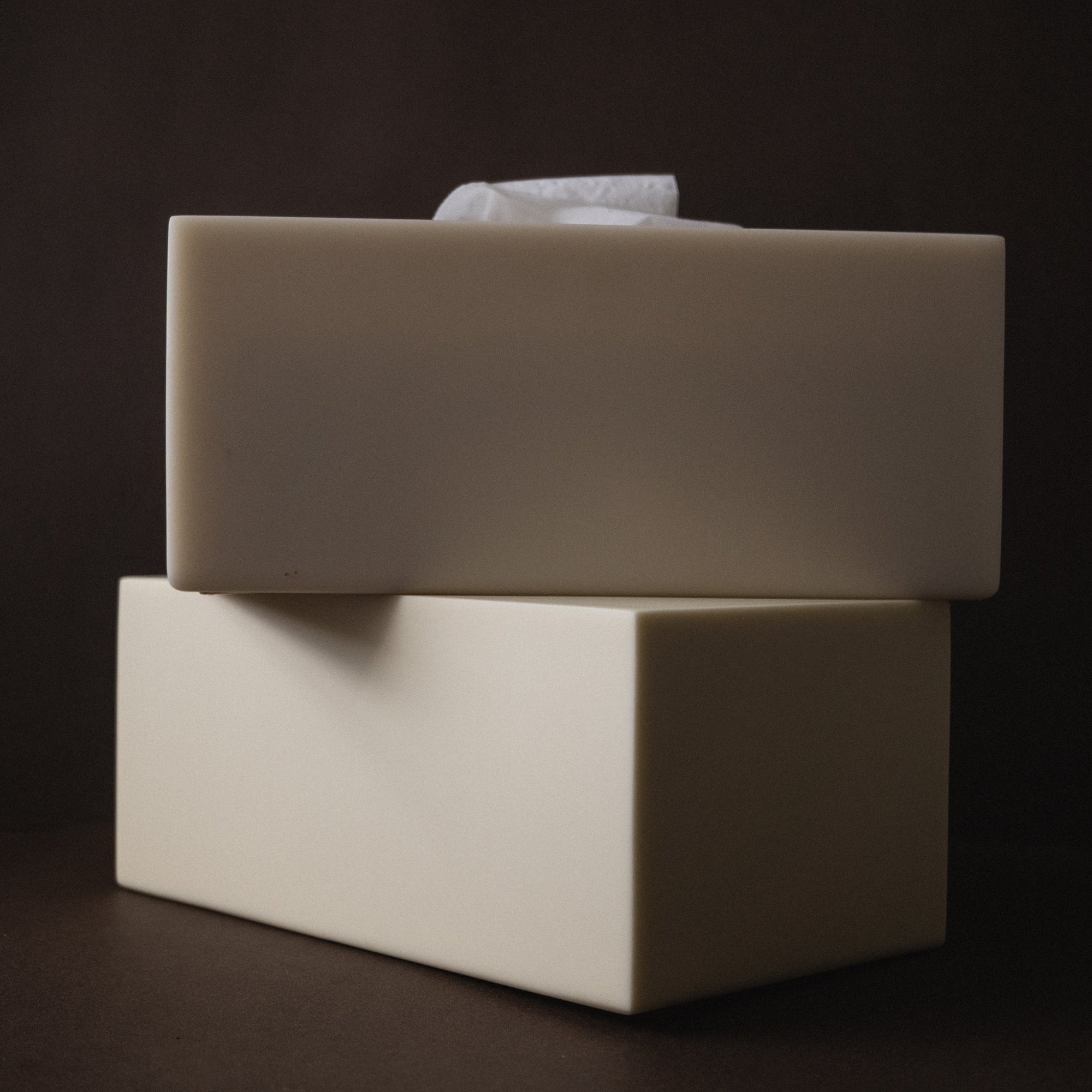 Two resin rectangular tissue covers stacked on a dark background