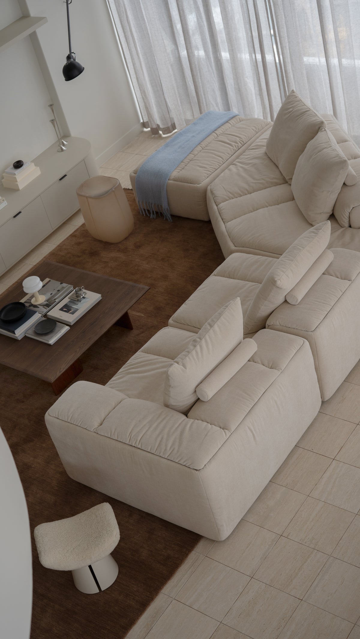 Trovato Penthouse living area with cream modular sofas and a dark timber coffee table