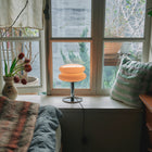 Table lamp on a windowsill with a view of trees outside
