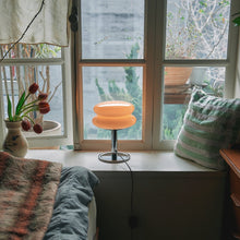 Table lamp on a windowsill with a view of trees outside