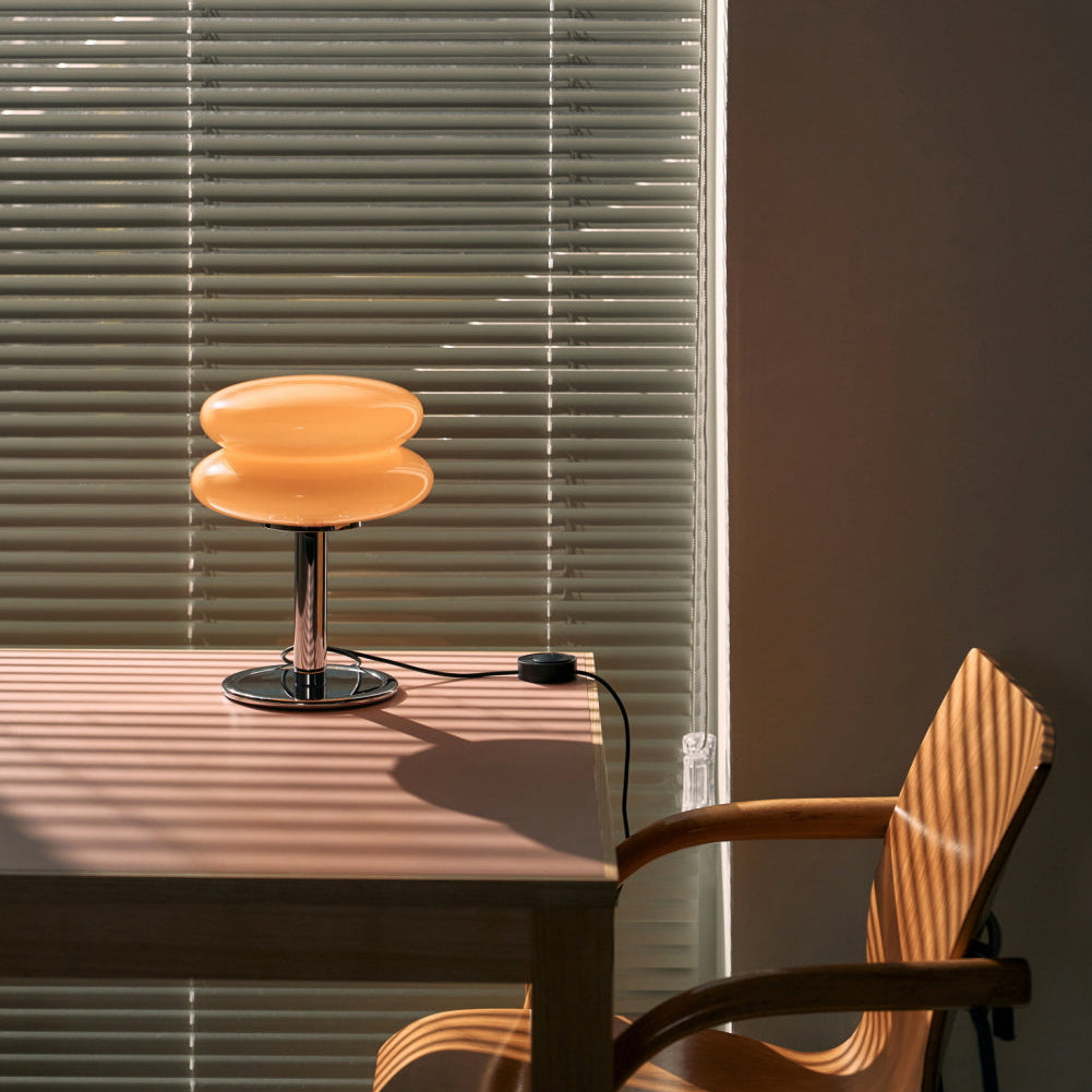 Table lamp on a table with a chair and blinds in the background
