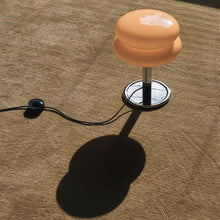 Table lamp on a brown carpet with a black cord