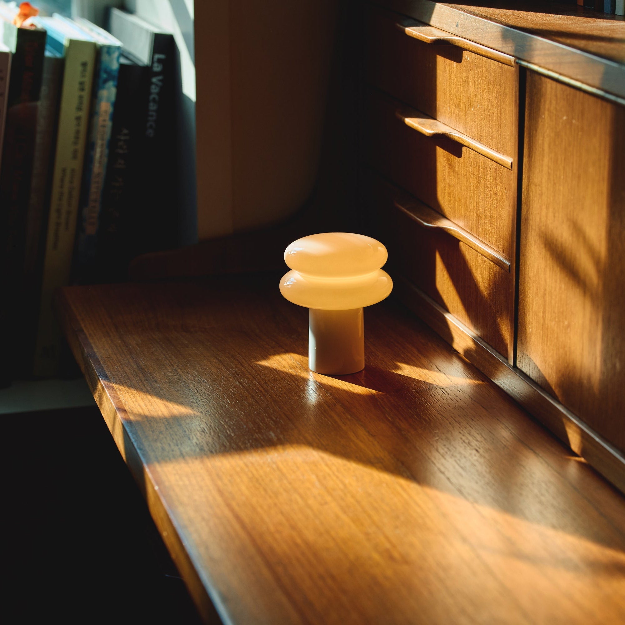Wooden desk with a small lamp and books in a cozy room