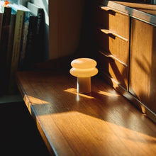 Wooden desk with a small lamp and books in a cozy room