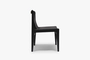 Side view of the Burano dining chair in Nero black full-grain leather with a black-stained solid ash frame on white.