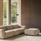 SOLACE 3-seat modular sofa and ottoman in River Clay upholstery in a warm modern living room