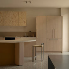 Tira Barstool beside a curved kitchen island in a light timber interior