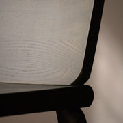 Close-up of the Tachi chair’s curved backrest and seat joinery in green aniline-stained solid ash.